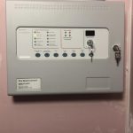 Fire-alarm-mounted-on-pink-wall